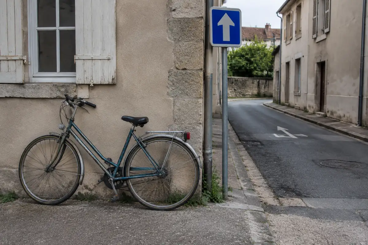 Vélo garé contre un mur devant l'entrée d'une rue à sens unique